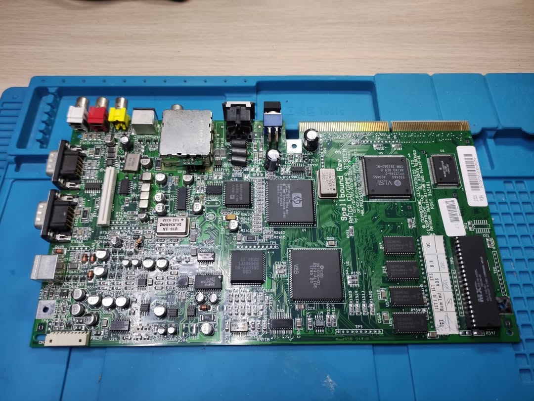 Scheda madre Amiga CD32 posizionata sul banco da lavoro pronta per il recap completo dei condensatori